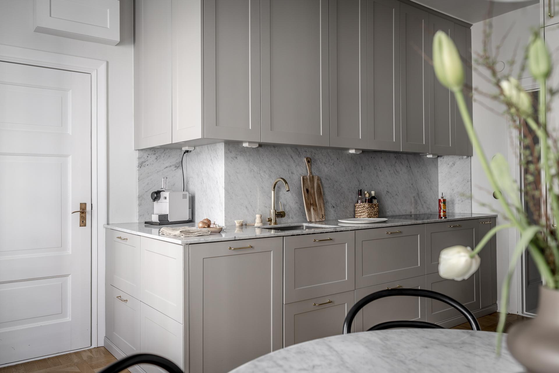 Bänkskivor i marmor, köksentrén ner mot gården skymtar