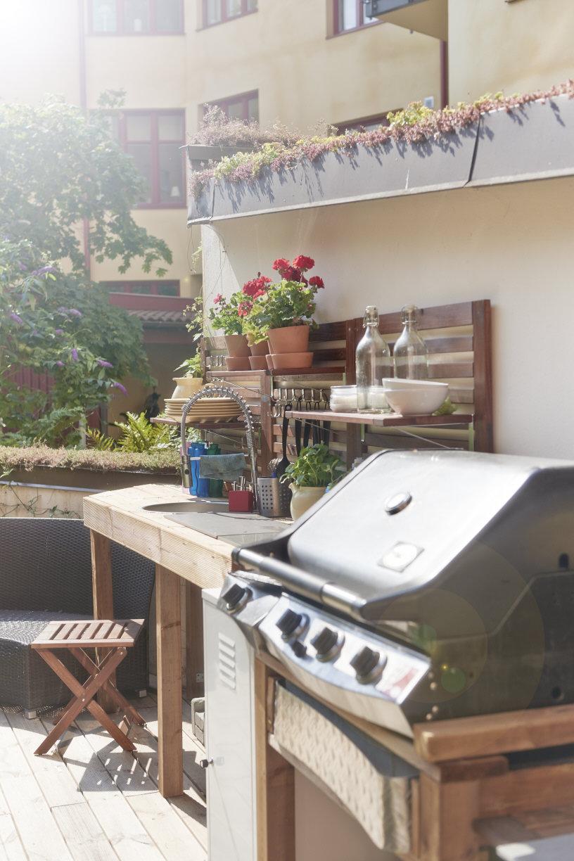 Uteköket med grill, rinnande vatten och färska kryddor