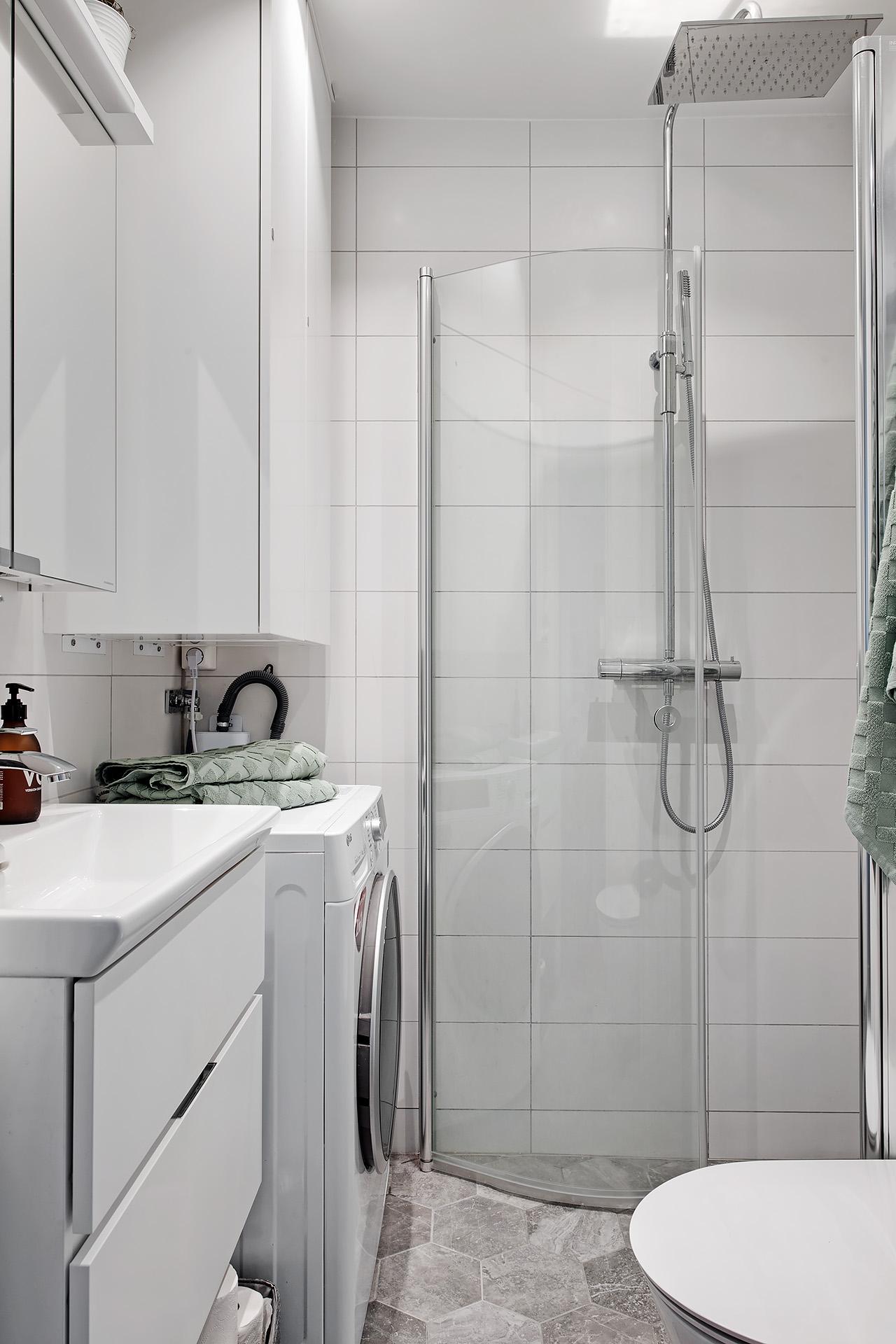 Nyrenoverat badrum med kombinerad tvättmaskin och torktumlare