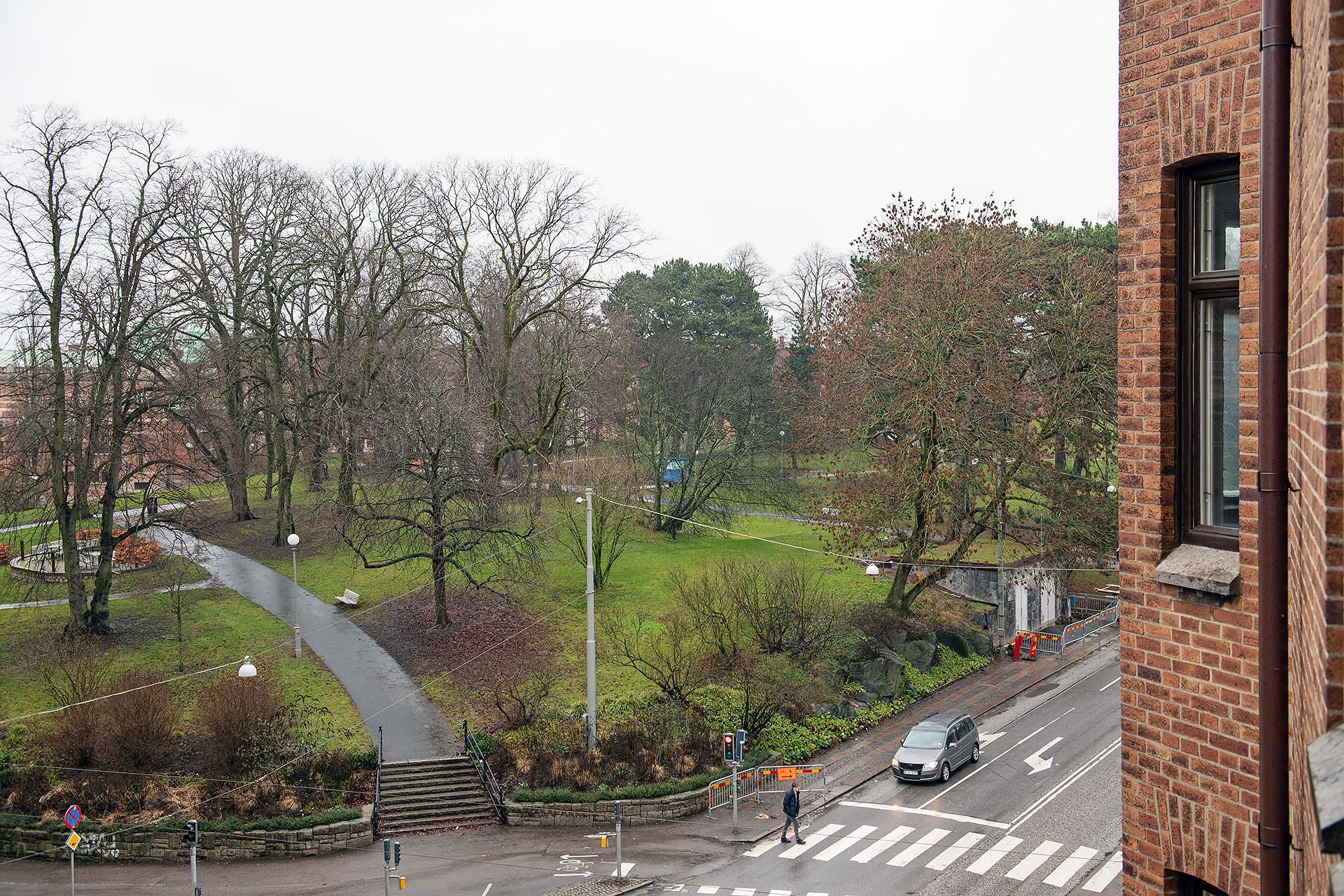 Vy från vardagsrum utöver park och stenstad