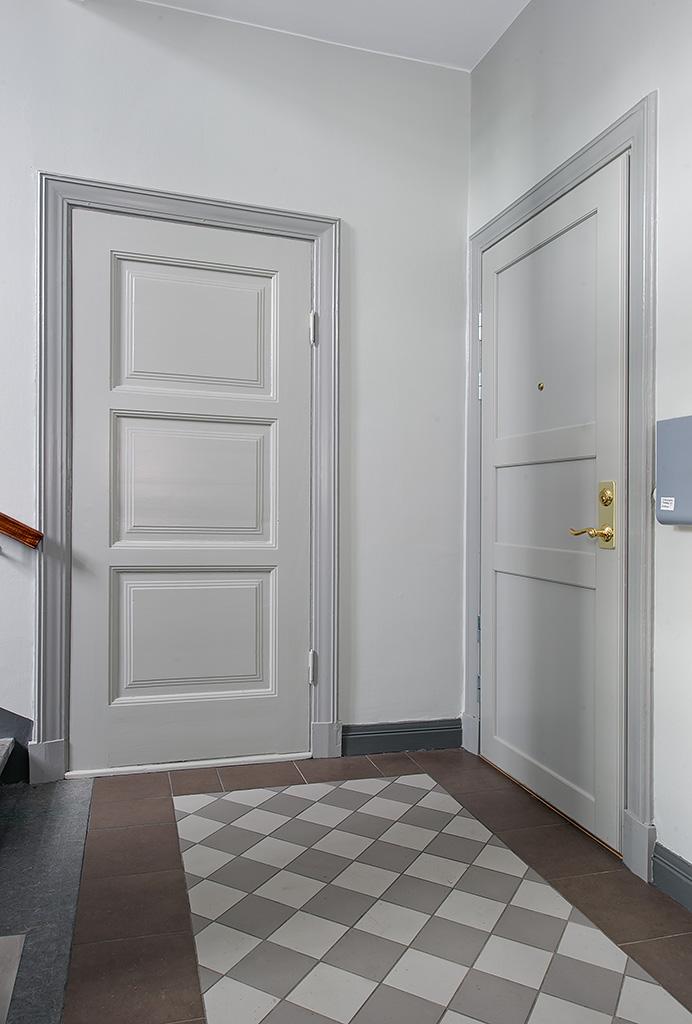 Nyligen renoverat trapphus med säkerhetsdörrar som leder in