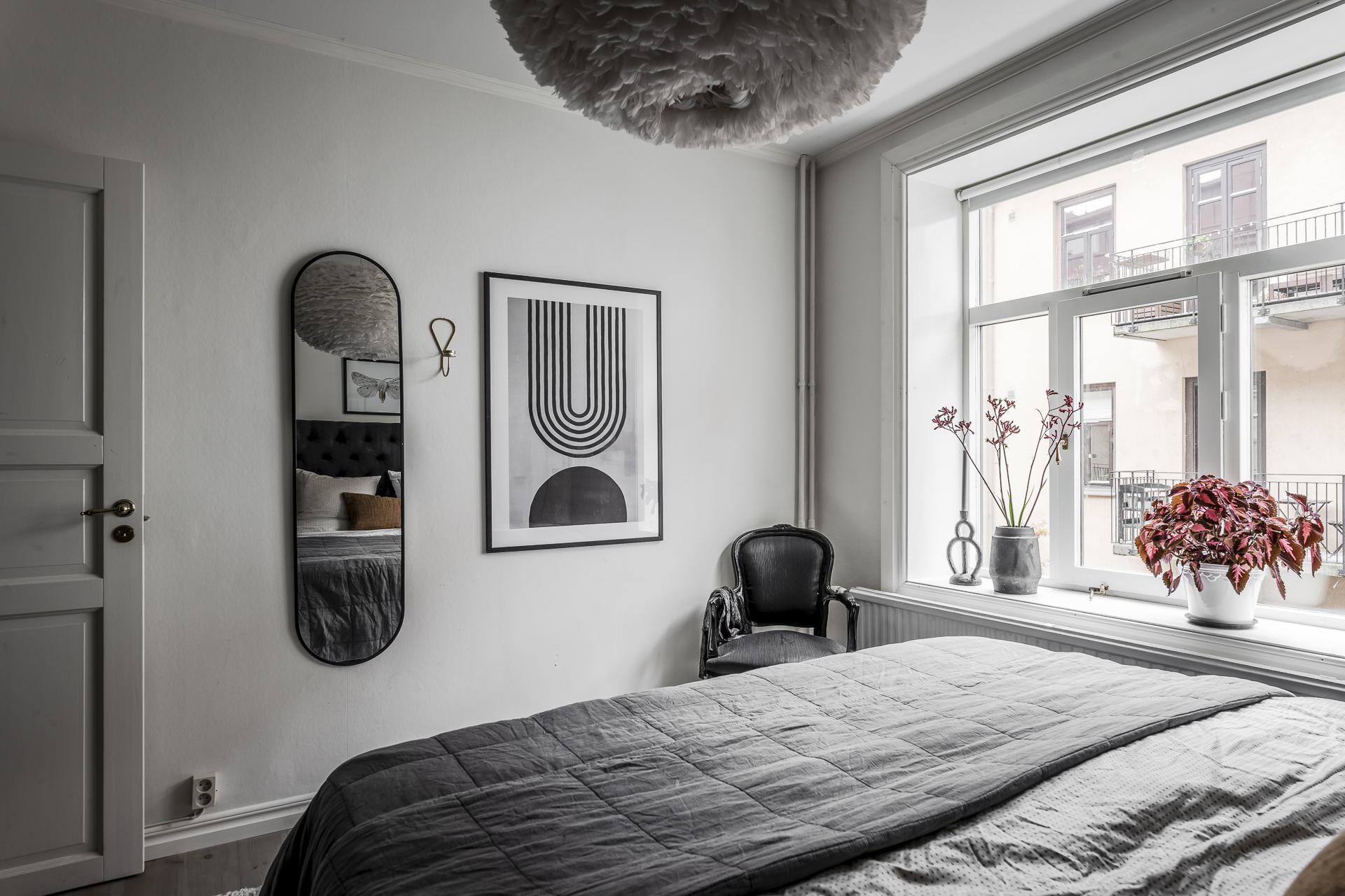 Ett kvadrtatiskt sovrum med bra plats för både dubbelsäng och en hel garderobsvägg