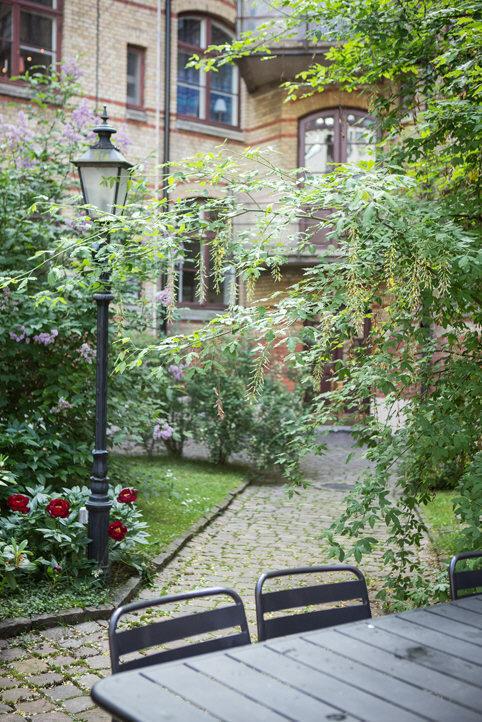 Renoverad innergård med kullerstenar och grill