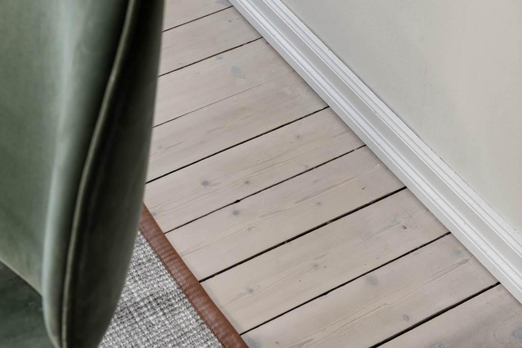 Vitpigmenterade brädgolv i vardagsrum och sovrum