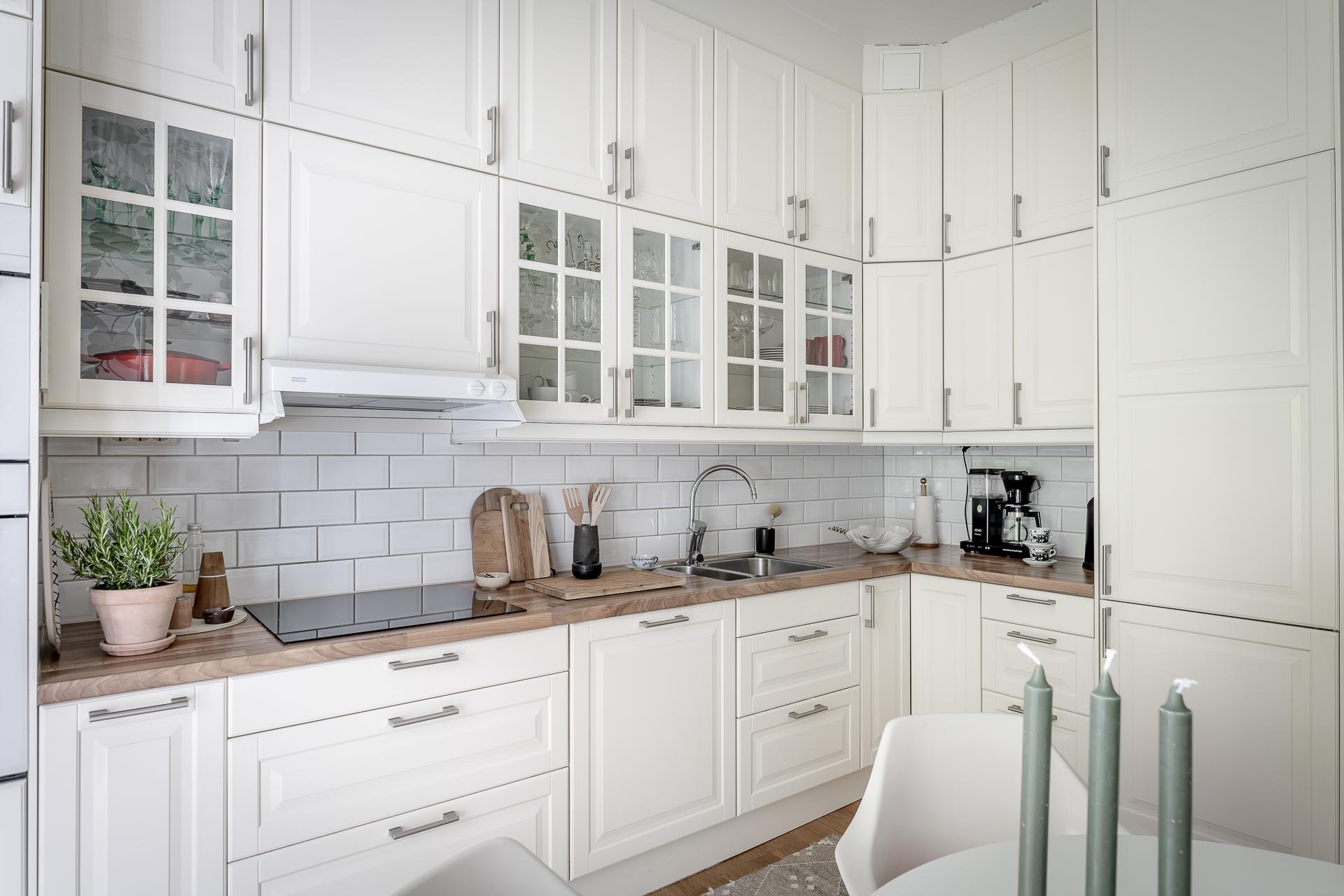 Vackert, tidssmickrande kök med vitrinskåp