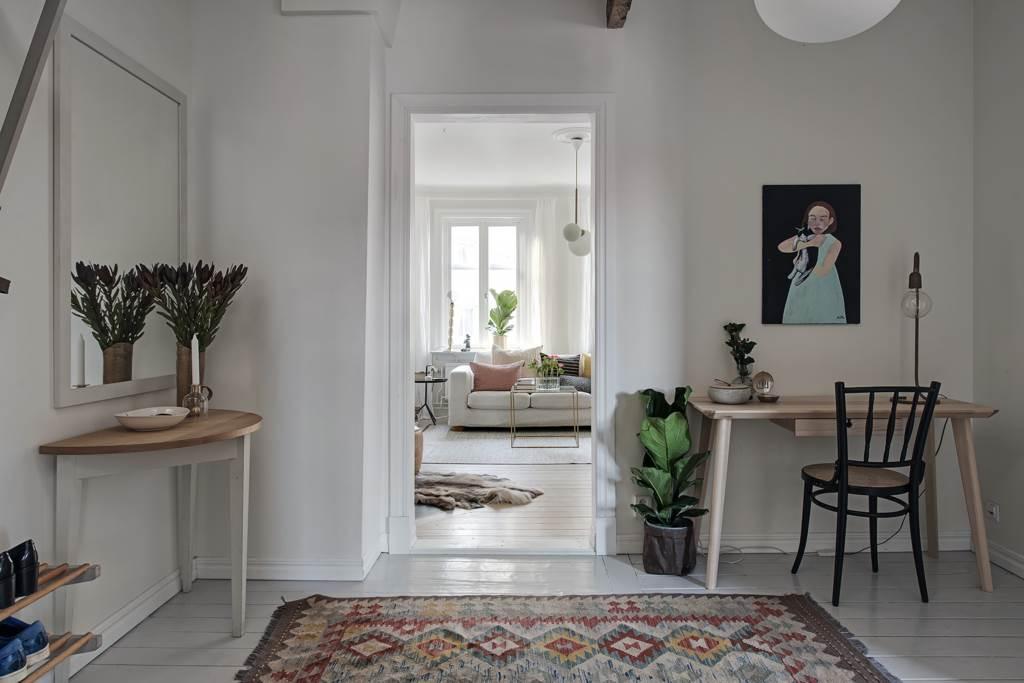 Rymlig och möblerbar hall med gråmålade brädgolv