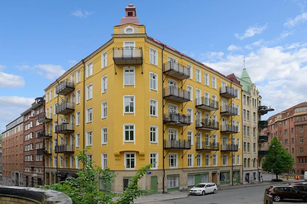 Brf Kastellanens solgula fastighet i hörnet av Kastellgatan och Risåsgatan