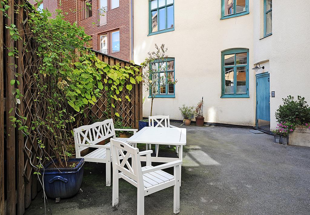 Mindre innergård med sittgrupp, grill och växter