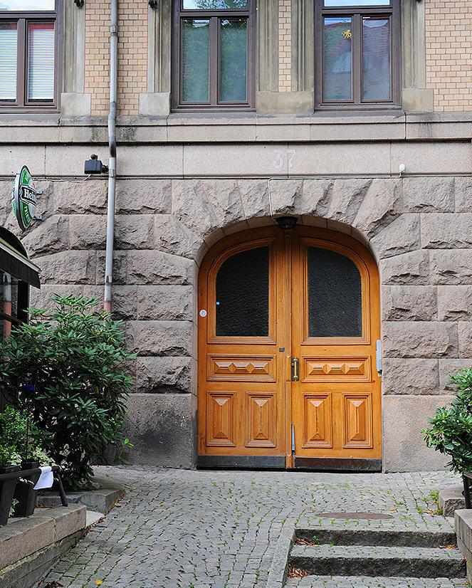 Stig in genom porten och tvärs över gården